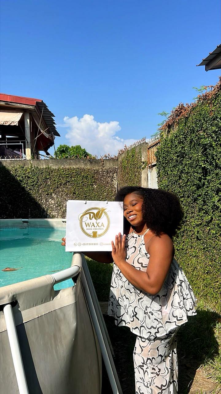 Cliente WAXA MODE CREATION posant avec un sac de la marque